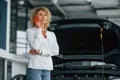 Woman with curly blonde hair is in autosalon
