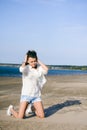 Woman with curly hair, the romance of youth, a journey walk on a warm summer sunny day on a sandy beach with water Royalty Free Stock Photo