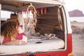 Woman with curly hair and striped sweater sleeping and dreaming on home van, lulled by the sea breeze. Concept of independence,