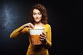 Woman with curly hair takes some popcorn biting her underlip Royalty Free Stock Photo