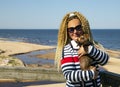 A woman with curly hair on a walk with a dog on the shore of the Baltic Sea Royalty Free Stock Photo