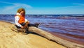 A woman with curly hair on a walk with a dog on the shore of the Baltic Sea Royalty Free Stock Photo