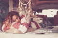 Woman with curly hair and warm sweater sleeping and dreaming on home van, lulled by the sea breeze. Concept of independence,