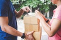 Woman customer appending signature in digital tablet and receiving a cardboard boxes parcel from delivery service courier, Home d