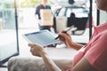 Woman customer appending signature in digital tablet and receiving a cardboard boxes parcel from delivery service courier, Home d