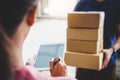 Woman customer appending signature in digital tablet and receiving a cardboard boxes parcel from delivery service courier, Home