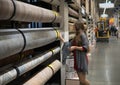 Woman customer choosing linoleum flooring in hypermarket