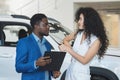 Woman customer enjoys African American salesman car offer