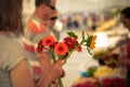 A woman customer makes a bouquet by a street seller of fresh flowers, a florist