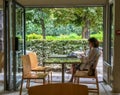 Woman customer relaxes at cafe table on the grounds of the Rodin Museum in Paris, France