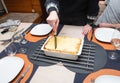 Woman cut with knife hot tasty home baking lasagna in ceramic casserole dish Royalty Free Stock Photo