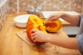 Woman cut the pumpkin with a knife in her kitchen Royalty Free Stock Photo