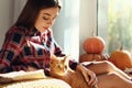 Woman with cute cat resting at home on autumn day Royalty Free Stock Photo