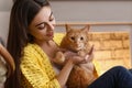 Woman with cute cat resting near fireplace Royalty Free Stock Photo