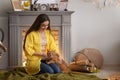 Woman with cute cat resting near fireplace Royalty Free Stock Photo