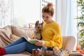 Woman with cute dog reading book at home Royalty Free Stock Photo