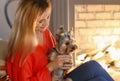 Woman with cute dog resting near fireplace Royalty Free Stock Photo