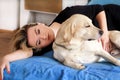 Woman with cute dogs at home. Handsome girl resting and sleeping with her dog in bed in bedroom. Owner and dog sleeping in sofa. Royalty Free Stock Photo