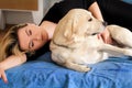 Woman with cute dogs at home. Handsome girl resting and sleeping with her dog in bed in bedroom. Owner and dog sleeping in sofa. Royalty Free Stock Photo