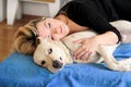 Woman with cute dogs at home. Handsome girl resting and sleeping with her dog in bed in bedroom. Owner and dog sleeping in sofa. Royalty Free Stock Photo