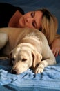 Woman with cute dogs at home. Handsome girl resting and sleeping with her dog in bed in bedroom. Owner and dog sleeping in sofa. Royalty Free Stock Photo