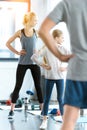 Woman and cute girl exercising with coach at fitness studio Royalty Free Stock Photo