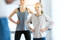 Woman and cute girl exercising with coach at fitness studio Royalty Free Stock Photo