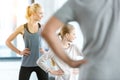 Woman and cute girl exercising with coach at fitness studio Royalty Free Stock Photo