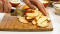 Woman cuts apples on a wooden cutting board. Royalty Free Stock Photo