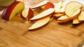 Woman cuts apples on a wooden cutting board. Royalty Free Stock Photo