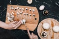 Woman cuts champignons on a cutting board with mushrooms. Hands of a girl with a knife and mushrooms on a dark background. Top Royalty Free Stock Photo