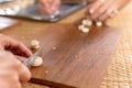 Woman cuts dough for baking knife, dough lying on wood board