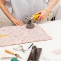 Woman cuts fabric in the studio. Tailor seamstress works on workplace