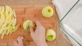 Woman cuts fresh peeled apples on a wooden cutting board on rustic background, view from above Royalty Free Stock Photo