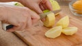 Woman cuts fresh peeled apples on a wooden cutting board Royalty Free Stock Photo