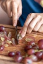 A woman cuts grapes on a cutting board. Royalty Free Stock Photo