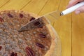 Woman cuts into a home-made pecan pie Royalty Free Stock Photo