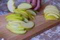 Woman cuts by knife an apple to slices on a cutting board on a table in the kitchen. Chantecler apples Royalty Free Stock Photo