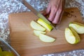 Woman cuts by knife an apple to slices on a cutting board on a table in the kitchen. Chauntecleer apples Royalty Free Stock Photo