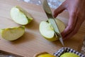 Woman cuts by knife an apple to slices on a cutting board on a table in the kitchen. Chauntecleer apples Royalty Free Stock Photo
