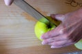 Woman cuts by knife an apple to slices on a cutting board on a table in the kitchen. Chauntecleer apples Royalty Free Stock Photo