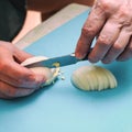 Woman cuts with a knife a white boiled egg Royalty Free Stock Photo