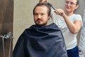 A woman cuts a man`s hair with scissors in the bathroom close up. The concept of grooming and problems with appearance when Royalty Free Stock Photo