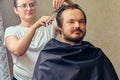 A woman cuts a man`s hair with scissors, close-up. The concept of closed salons and barbershop during the isolation of coronaviru Royalty Free Stock Photo