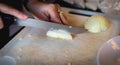 Woman cuts onions on a white plastic board Royalty Free Stock Photo