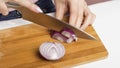 A woman cuts Red onions with a knife on a cutting Board Royalty Free Stock Photo