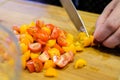 A woman cuts small colorful plum tomatoes on a cutting board. Cooking.