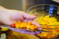 A woman cuts small colorful plum tomatoes on a cutting board. Cooking.