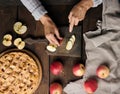 Woman cutting apples for pie on brown wooden table, top view Royalty Free Stock Photo