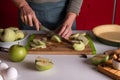 Woman cutting apples on a wooden cutting board for homemade traditional apple pie Royalty Free Stock Photo